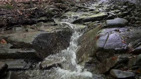 A beautiful mountain stream flows down to the stone 4 k Stock Footage 138868732