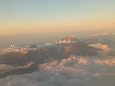 Beautiful mountain view from inside the plane with sunset and white clouds Foto stock