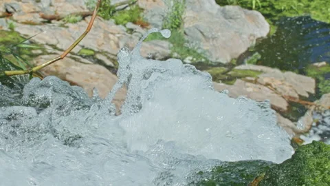 A beautiful mountain waterfall flows through the rocks, its water washes stones Stock Footage 201410077