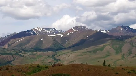 Beautiful Mountains with snow-capped peaks, covered with green forest. Stock Footage
