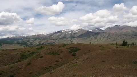 Beautiful Mountains with snow-capped peaks, covered with green forest. Stock Footage