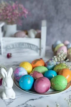 Beautiful multi -colored decorated Easter eggs and a cute white Easter rabb.. Stock Photos