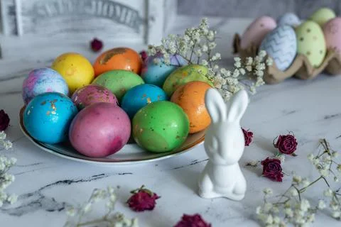 Beautiful multi -colored decorated Easter eggs and a cute white Easter rabb.. Stock Photos