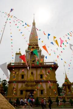 Beautiful multi-colored flags on the background of the Chalong Temple. Stock Photos