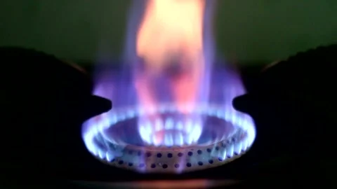 A beautiful multi-colored flame burns from gas on a stove burner in the dark Stock Footage 332062726