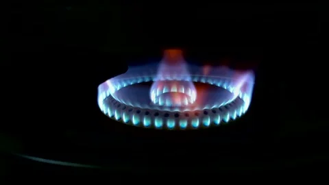 A beautiful multi-colored flame burns from gas on a stove burner in the dark Stock Footage 332062735