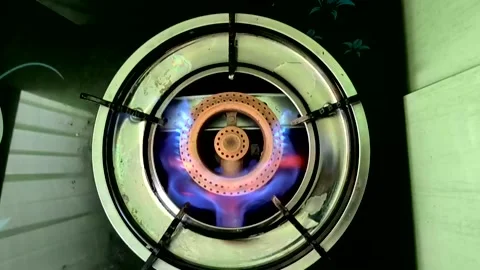 A beautiful multi-colored flame ignites from gas on a stove burner Stock Footage 332063438