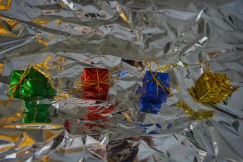 Beautiful multi-colored four packaged gifts for holidays and new year on silver Stock Photos