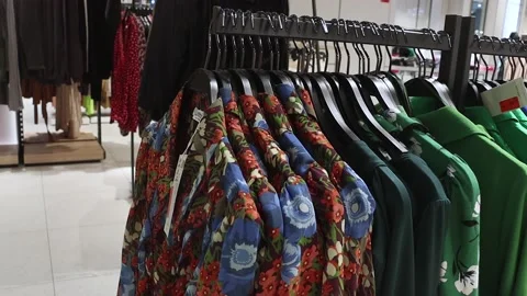 Beautiful multi-colored shirts hanging on a hanger in a store. Stock Footage 211118713