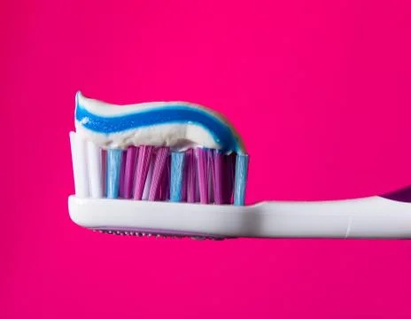 Beautiful multi-colored toothbrush with toothpaste close-up. Stock Photos
