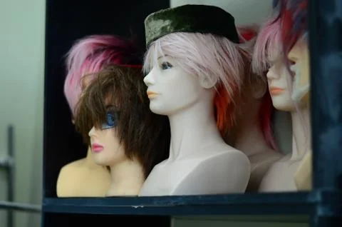 Beautiful multi-colored wigs stand on a shelf 写真素材