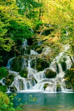 Beautiful multi-level waterfall flowing over mossy stones in clean mountain.. Stock Photos
