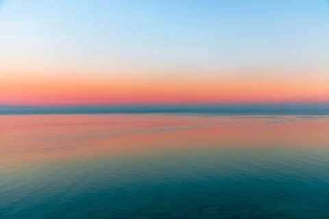 Beautiful multicolor sunset reflected in the waters of Lake Garda, Italy. Stock Photos