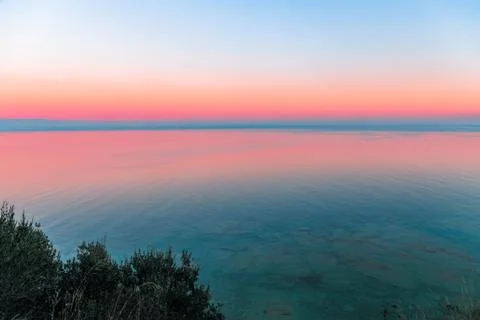 Beautiful multicolor sunset reflected in the waters of Lake Garda, Italy Stock Photos