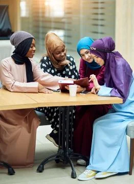 Beautiful Muslim and Arabic girls reading Koran together in group. Stock Photos
