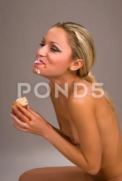 Beautiful naked woman eating a hamburger Stock Photos
