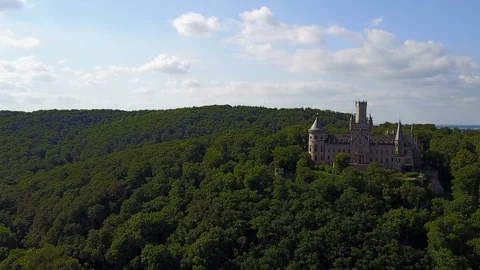 Beautiful neo-gothic Marienburg castle sideway aerial sunny forest mountain 4k Stock Footage