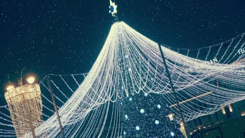 Beautiful New Year's tree with luminous garlands and balls in the city square Stock Footage 330889206