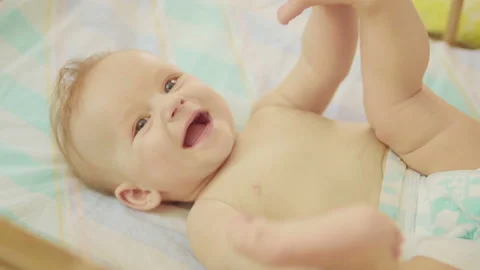 Beautiful newborn lying on back looking into camera and smiling. Stock-Footage 93766000
