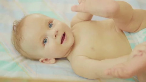 Beautiful newborn lying on back looking into camera and smiling. Stock Footage 93766086