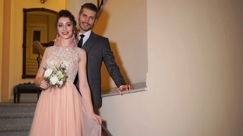 Beautiful newlywed couple posing in the chic expensive indoor on the steps Vídeos de archivo 102619387