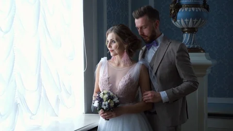 Beautiful newlywed couple posing in the chic expensive indoor by the window 库存影片 102624435