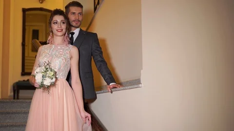 Beautiful newlywed couple posing in the chic expensive indoor on the steps 動画素材 103156194