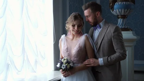 Beautiful newlywed couple posing in the chic expensive indoor by the window. the Stock Footage 103163635