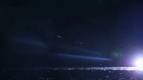 Beautiful night snowfall and light from the car headlights. Winter landscape Stock Footage 76226334