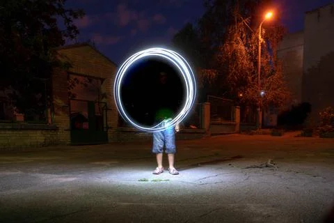 Beautiful night view of a man creating a light circle effect Stock Photos