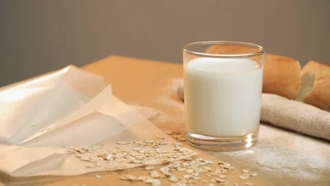 Beautiful oat biscuits in a stack next to a glass of milk on a light background. Video stock 131308824
