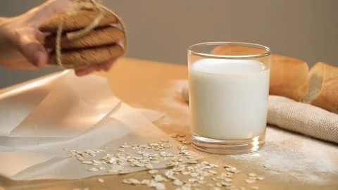 Beautiful oat biscuits in a stack next to a glass of milk on a light background Stock Footage 131309813