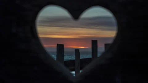 Beautiful ocean golden sunset shot through heart - timelapse Stock Footage 220026053