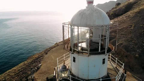 Beautiful ocean with sun rays reflection washes old lighthouse against pier.  Stock Footage 162977032