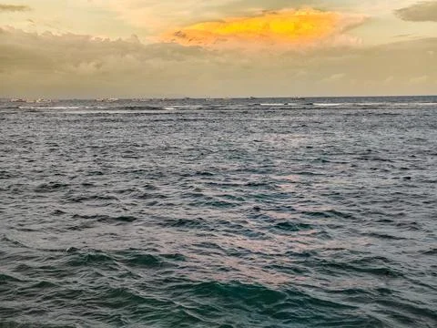 Beautiful ocean wave texture at sunset with boats on the horizon Stock Photos