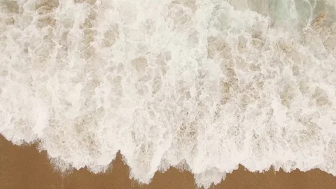 Beautiful ocean waves and splashes on a sandy beach in Nazar , Portugal. Aerial Stock Footage 80900088