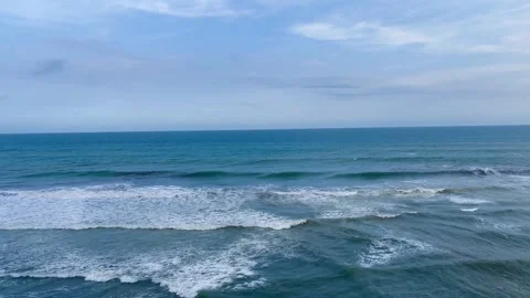 Beautiful Ocean Waves Crashing Under a Cloudy Blue Sky Stock Footage 340256949