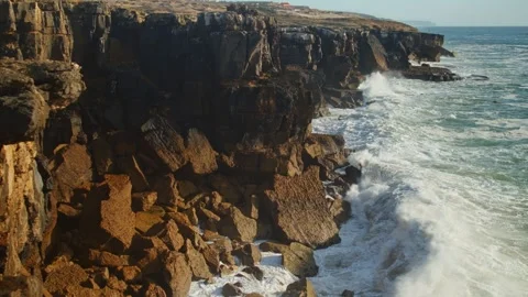 Beautiful ocean waves roll and crash onto the rocky shoreline of Portugal. Stock Footage 304572664