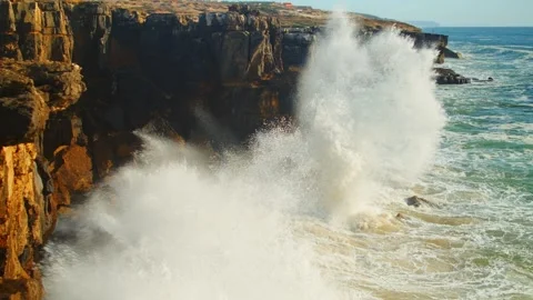 Beautiful ocean waves roll and crash onto the rocky shoreline of Portugal. Stock Footage 305828554