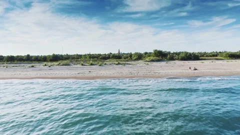 Beautiful old lighthouse on sand dune against blue sky with white clouds. Red Stock-Footage 132424573