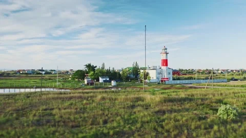 Beautiful old lighthouse on sand dune against blue sky with white clouds. Red Stock-Footage 132426519
