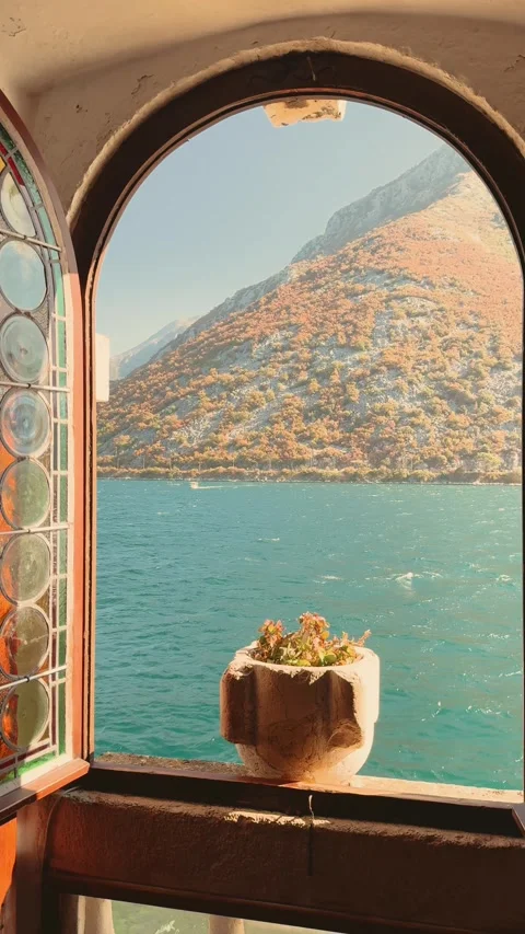 Beautiful old style arched window overlooking the sea turquoise water stormy Stock Footage 346784153