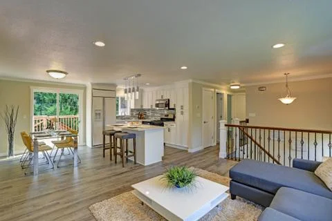 Beautiful open plan second floor white kitchen with dining space. Traditional Stock Photos