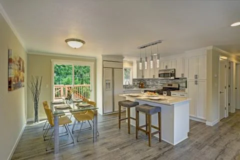 Beautiful open plan second floor white kitchen with dining space. Traditional Stock Photos