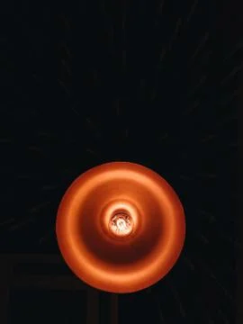 Beautiful orange lamp with an unusual light bulb on a black background Stock Photos