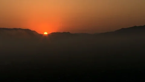 Beautiful orange sun setting behind the silhouette mountain Stock Footage 106203218