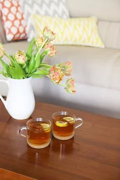 Beautiful orange tulips bouquet with two cups of tea Beautiful orange tuli... Stock Photos