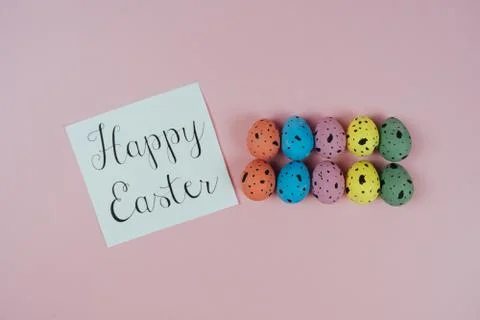 Beautiful painted Easter eggs and greeting card isolated on pink background Stock Photos