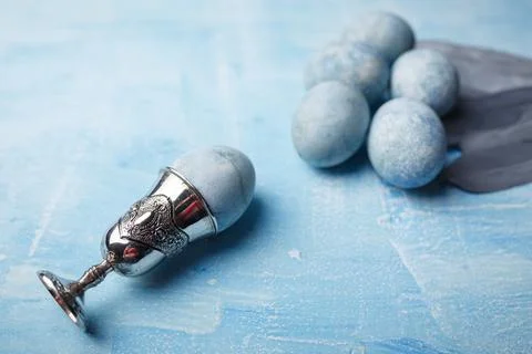 Beautiful painted easter eggs and silver feathers on blue background Stock Photos