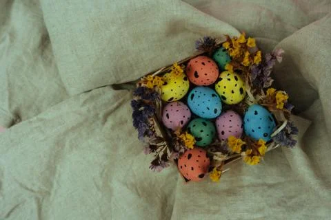 Beautiful painted Easter eggs with dried flowers in little box on linen cloth Stock Photos